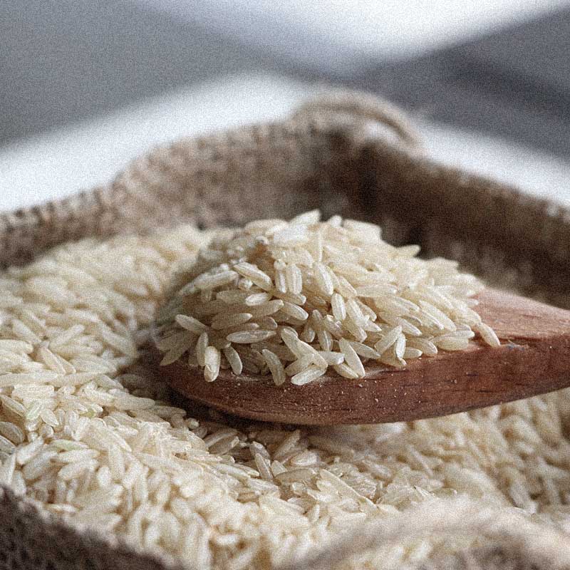 riz dans cuillère en bois dans un sac de lin